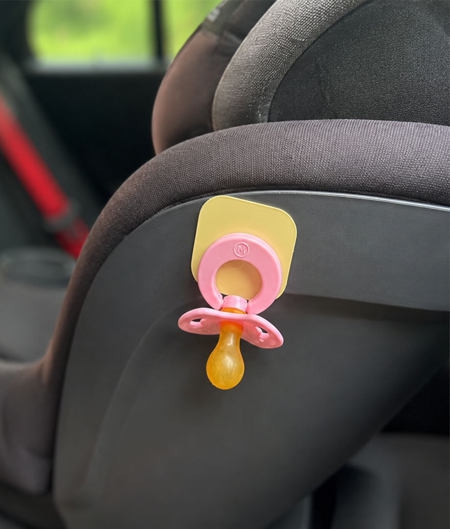 Blush Magnetot pacifier holder attached to a child car seat