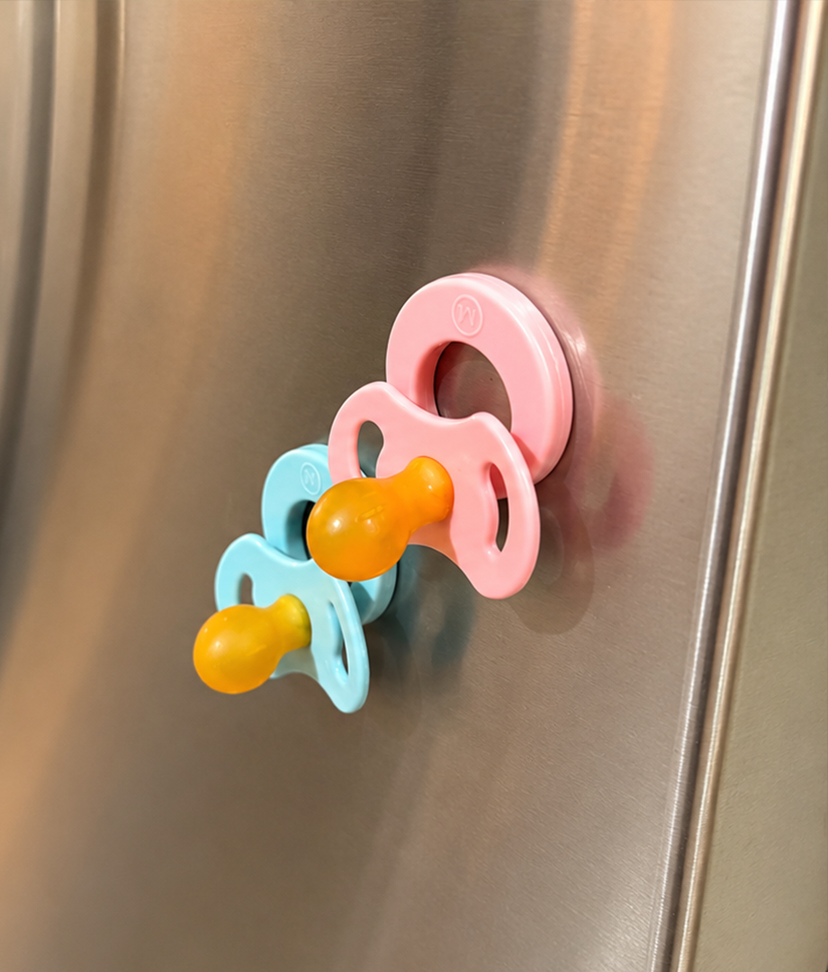 Sky and Blush Magnetot pacifiers kept visible on a refrigerator